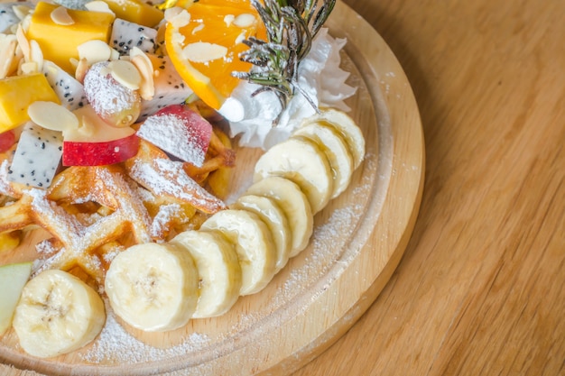 Gofres y fruta con helado en la mesa.