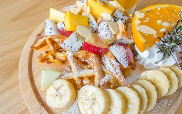 Gofres y fruta con helado en la mesa.