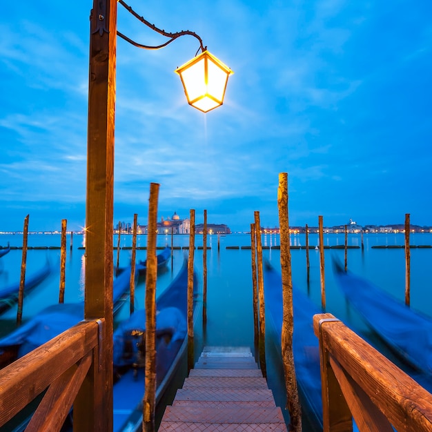 Foto gratuita las góndolas amarradas por la plaza san marcos con la iglesia de san giorgio di maggiore en el espacio - venecia, venecia, italia, europa