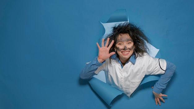 Goofy científico loco sonriendo y sonriendo a la cámara, haciendo tontas expresiones tontas. Mujer loca loca con cabello explosivo sintiéndose feliz y alegre, peinado loco, humo.