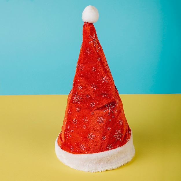 Gorro de navidad en fondo amarillo y azul