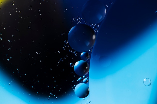 Gotas de aceite azul sobre un fondo abstracto de superficie de agua