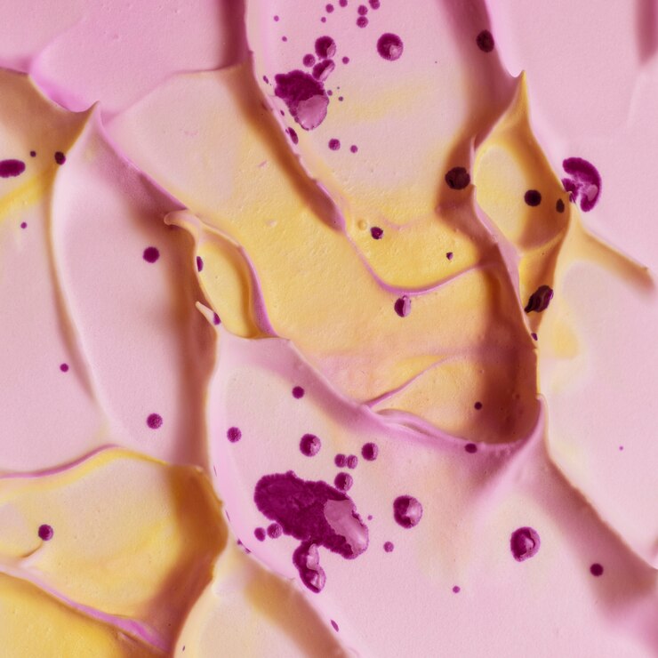 Foto gratuito gotas de acuarela violeta sobre superficie de espuma texturizada cremosa amarilla y rosa