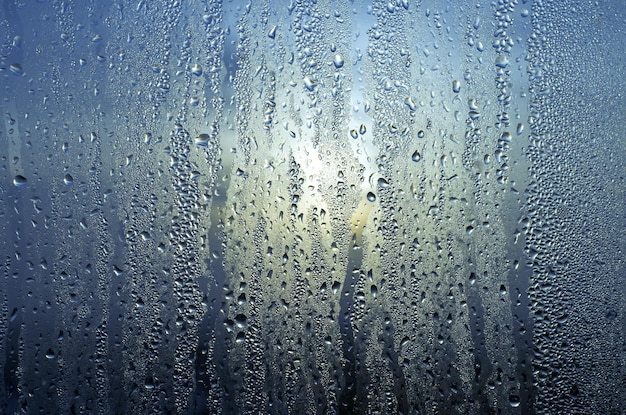Gotas de lluvia de agua natural sobre el vidrio en la ventana Fondo de textura abstracta
