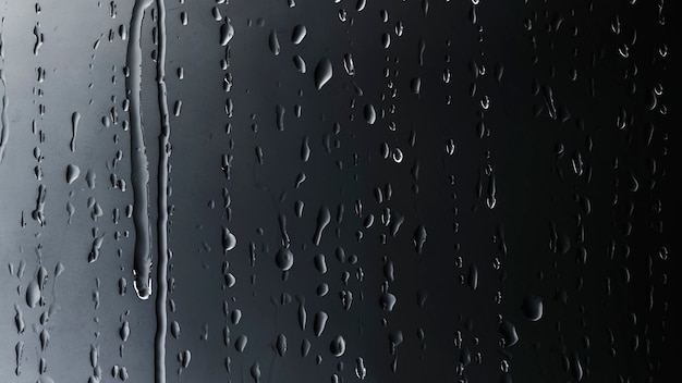 Foto gratuita gotas de lluvia sobre fondo negro de vidrio