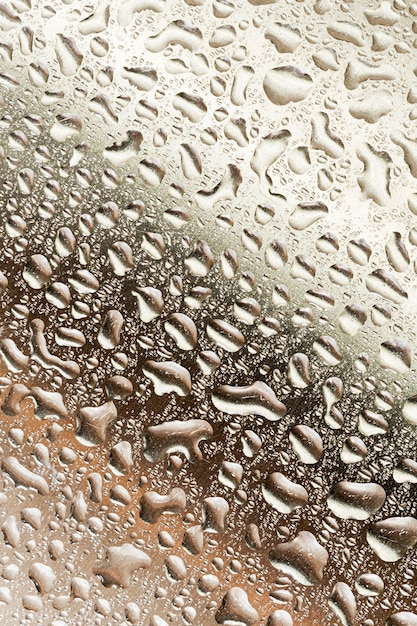 Gotas de lluvia sobre la pared metálica marrón degradado