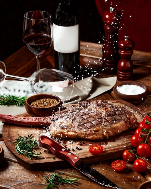 gotas de sal caen sobre el filete de ternera servido con vino