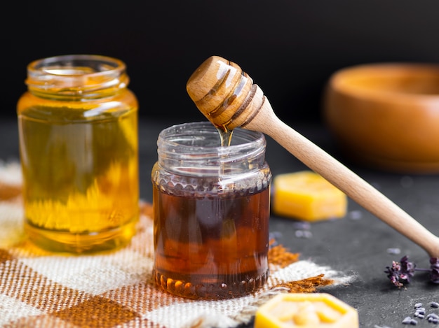 Foto gratuita goteando miel en frasco de vidrio