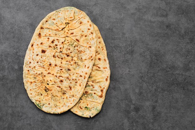 Gozleme, un plato vegetariano tradicional de la cocina turca o caucásica en forma de pan plano relleno de verduras y queso envuelto en el interior Horneado en una sartén Vista superior con espacio para copiar