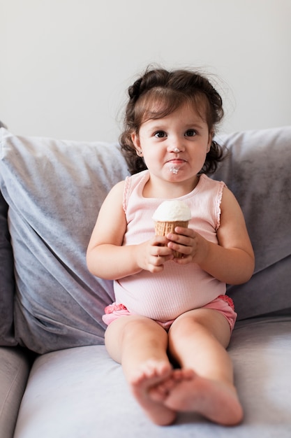 Foto gratuita graciosa comiendo un helado en el sofá