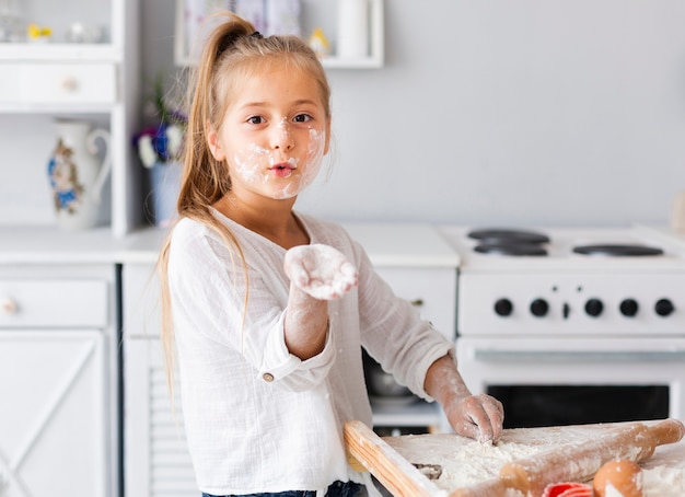 Foto gratuita graciosa niña mostrando su mano con harina