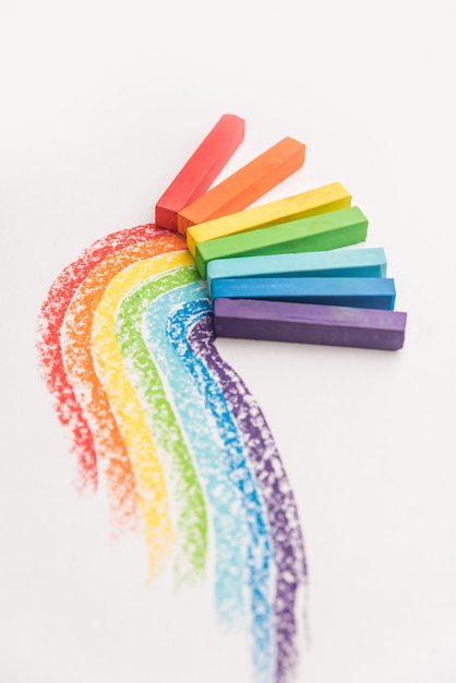 Gradiente de arco iris hecho de tizas de crayón pastel sobre las huellas coloridas