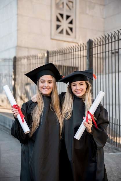 Graduados universitarios de tiro medio sonriendo