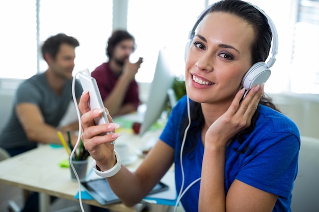 Foto gratuita gráfico hembra de escuchar música desde el teléfono móvil de diseño