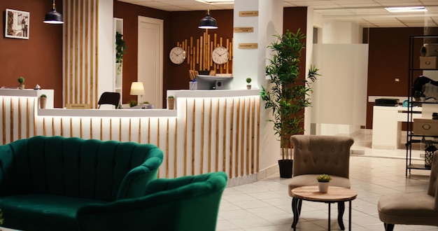 Foto gratuita gran angular del salón del hotel de alojamiento de viaje con mostrador de recepción. interior elegante y vacío del vestíbulo del complejo moderno con muebles acogedores y una cálida chimenea lista para recibir a los turistas