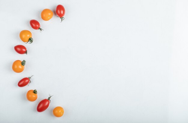 Gran angular de tomates rojos y amarillos relucientes sobre fondo blanco. Foto de alta calidad