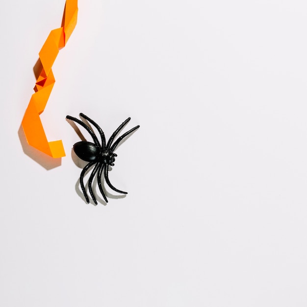 Foto gratuita gran araña negra con decoración de papel naranja