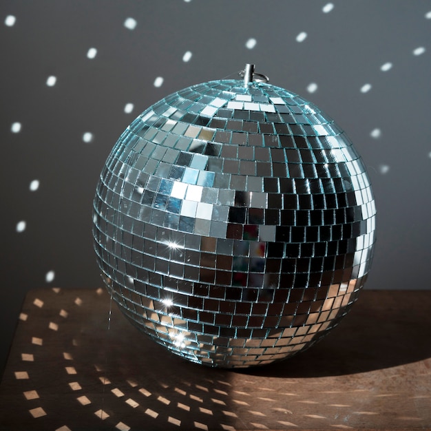 Gran bola de discoteca en piso marrón con luces de fiesta