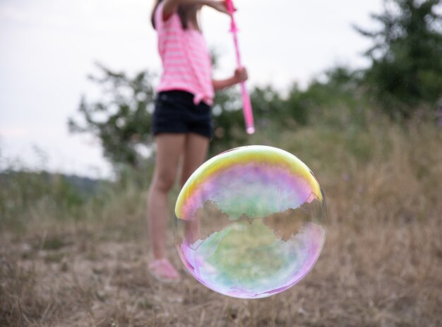 Gran burbuja de jabón multicolor sobre un fondo borroso.