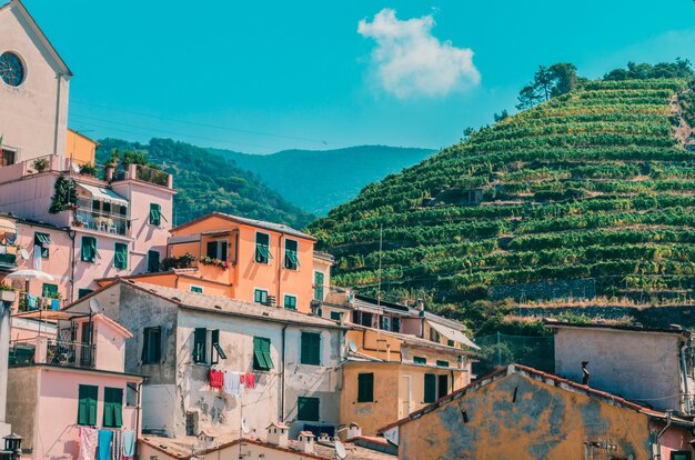 Gran cantidad de edificios cerca de montañas cubiertas de hierba verde bajo el cielo nublado