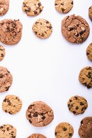 Foto gratuita gran cantidad de galletas con chispas de chocolate dispuestas en círculo sobre un fondo blanco con espacio de copia