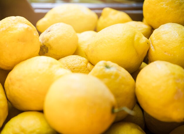 Gran cantidad de limones amarillos brillantes en supermercado