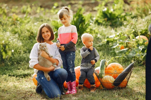 Gran familia sentada en un jardín cerca de muchas calabazas