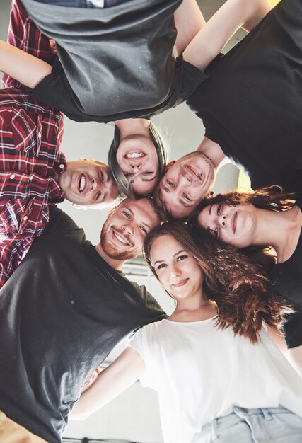 Un gran grupo de amigos sonrientes abrazándose juntos.