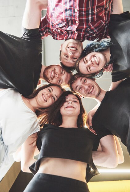 Un gran grupo de amigos sonrientes abrazándose juntos.