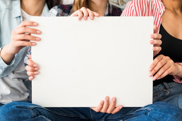 Gran hoja blanca de papel sujetada por mujeres.