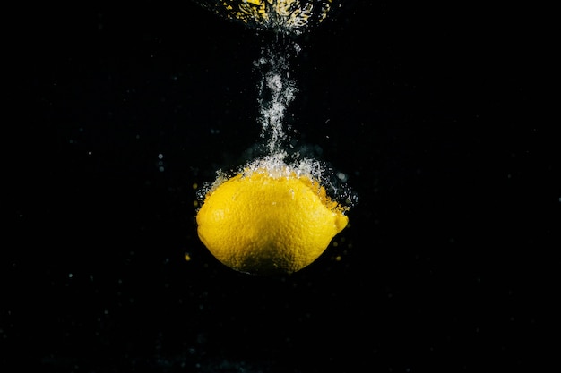 Gran limón fresco cae en el agua