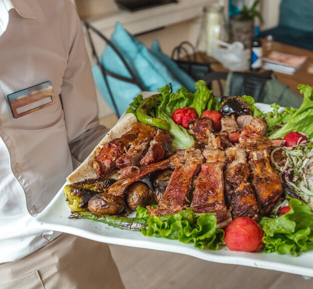 Un gran plato blanco de variedades de kebab