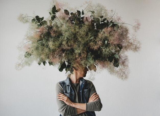 Gran ramo decorativo hecho de hojas verdes y musgo cuelga sobre la cabeza del hombre