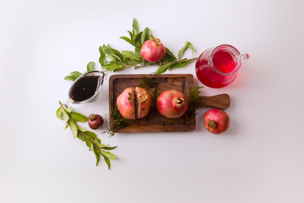 Granadas rojas y salsa en la tabla de madera