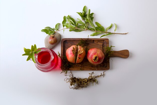 Granadas rojas y salsa en la tabla de madera