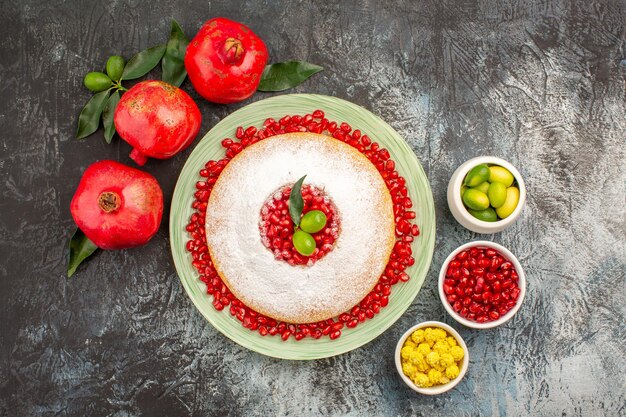 granadas tres apetitosas granadas un plato de tarta y tazones de bayas