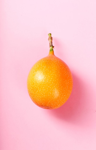 Foto gratuita granadilla en superficie rosa