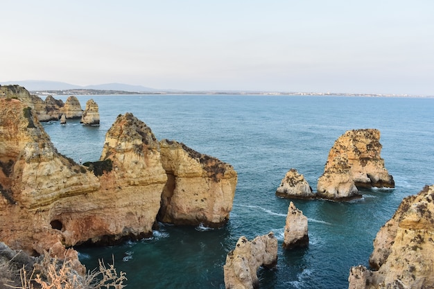 Grandes acantilados que sobresalen del agua durante el día en Portugal