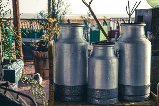 Foto gratuita grandes latas de leche de metal antiguo en la hermosa puesta de sol