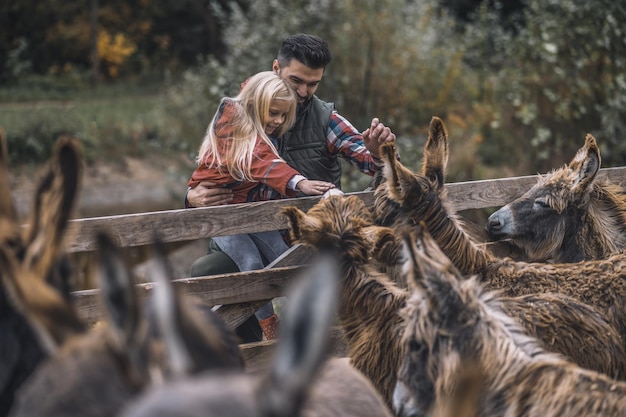 En la granja Farmer y una niña de pie cerca del corral de ganado.