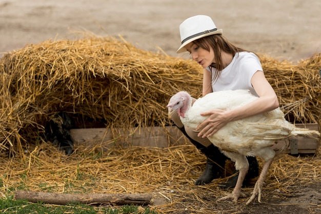 Foto gratuita granjera con un pavo en una granja