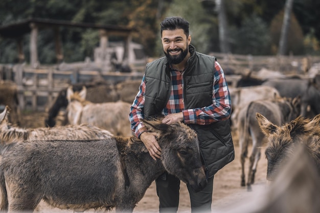 Foto gratuita un granjero con sus animales en el marco.