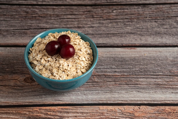 Foto gratuita granos de avena con frutos rojos en un tazón rústico