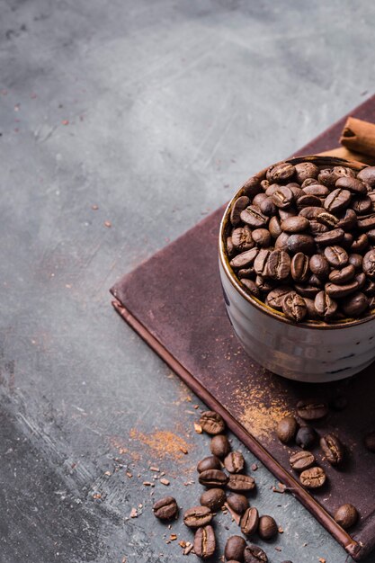 Granos de café de ángulo alto en taza sobre tabla de cortar con espacio de copia