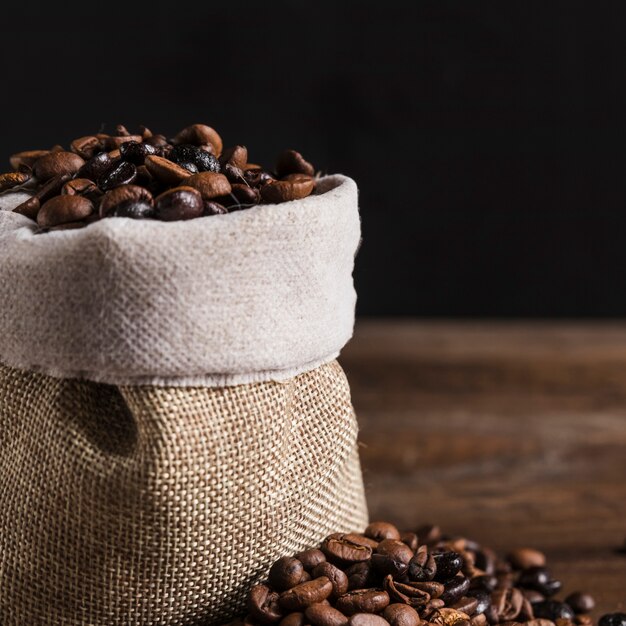 Granos de café en bolsa y en mesa