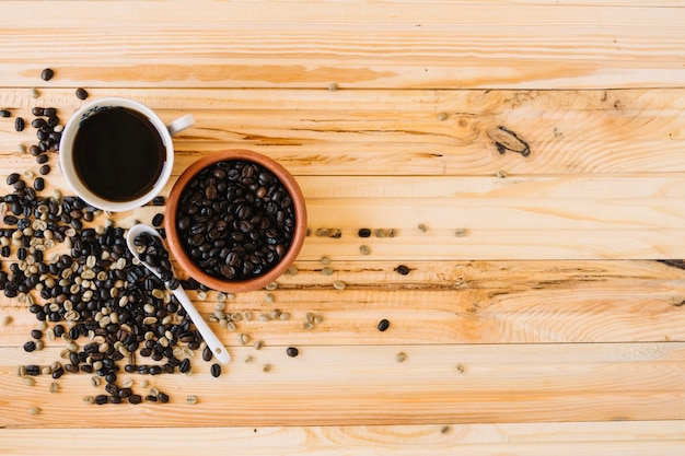 Granos de café cerca de la taza de café