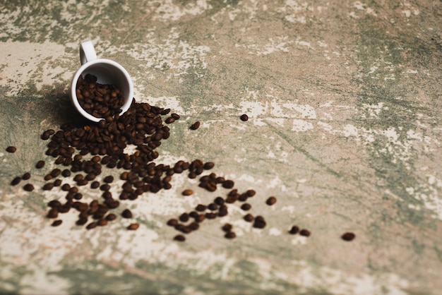 Granos de café derramados de la taza