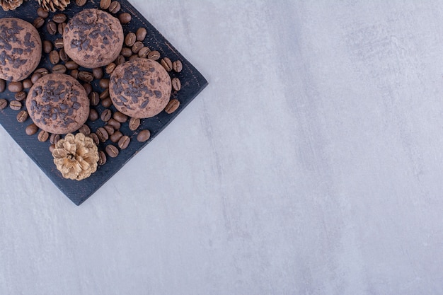 Granos de café, galletas y una piña sobre fondo blanco.