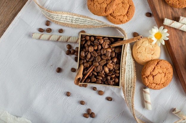 Granos de café y galletas sobre un mantel azul
