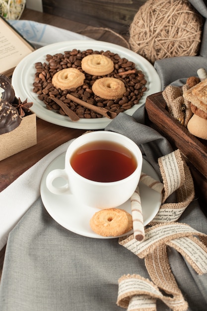 Granos de café, galletas y una taza de té.